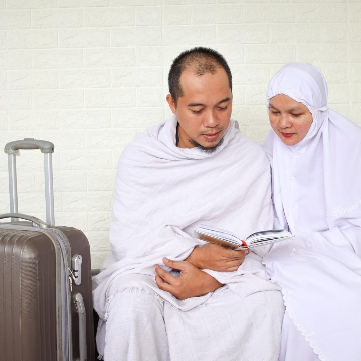 muslim-hajj-couple-in-white-clothes-praying-with-a-2023-11-27-05-31-20-utc.jpg